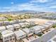 Scenic aerial view showcases modern homes with landscaping and mountain backdrop under a bright, partly cloudy sky at 11228 Burning River St, Las Vegas, NV 89183