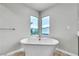 Bright bathroom showcases a soaking tub beneath dual windows at 11228 Burning River St, Las Vegas, NV 89183