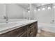Bathroom with double sinks, a large mirror, and a bath and shower combination at 11228 Burning River St, Las Vegas, NV 89183