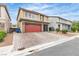 Charming two-story home featuring a red garage door and a meticulously paved driveway at 11228 Burning River St, Las Vegas, NV 89183
