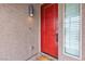 A striking red front door is complemented by a contemporary exterior light fixture at 11228 Burning River St, Las Vegas, NV 89183