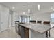 Kitchen island with pendant lights, sink, and granite countertops, adjoins living and dining areas at 11228 Burning River St, Las Vegas, NV 89183
