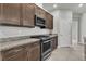 Close up of stainless steel oven and gas stovetop under an overhead microwave, and granite countertops at 11228 Burning River St, Las Vegas, NV 89183