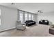 Spacious living room features large windows, neutral decor, and carpeted floors at 11228 Burning River St, Las Vegas, NV 89183