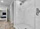 Walk in shower featuring white marble walls and tile floors at 11228 Burning River St, Las Vegas, NV 89183
