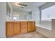 Bathroom with dual sinks, white counter, tub, large mirror and vanity lights at 11668 Tierney Creek Dr, Las Vegas, NV 89183