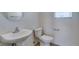 A half bathroom with a pedestal sink, toilet and a mirror at 11668 Tierney Creek Dr, Las Vegas, NV 89183