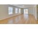 A spacious living room featuring light-colored wood flooring and multiple windows at 11668 Tierney Creek Dr, Las Vegas, NV 89183
