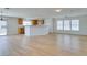 Spacious open-concept living room, with light wood-look laminate flooring and a kitchen with wooden cabinets at 11668 Tierney Creek Dr, Las Vegas, NV 89183