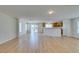 Spacious open-concept living room, with light wood-look laminate flooring and a kitchen with wooden cabinets at 11668 Tierney Creek Dr, Las Vegas, NV 89183
