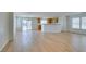 Spacious open-concept living room, with light wood-look laminate flooring and a kitchen with wooden cabinets at 11668 Tierney Creek Dr, Las Vegas, NV 89183