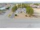 Aerial view of home features xeriscaped front yard, RV parking, and tile roof at 151 Hornet St, Pahrump, NV 89048