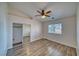 Bright bedroom with wood-look floors, ceiling fan, and closet with mirrored sliding doors at 151 Hornet St, Pahrump, NV 89048