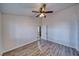 Simple bedroom with wood-look flooring, ceiling fan, and doorway to the front of the house at 151 Hornet St, Pahrump, NV 89048