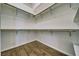 Bright walk-in closet with hardwood floors, white walls, wooden closet rod, and metal support brackets at 151 Hornet St, Pahrump, NV 89048