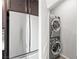 Modern stainless steel refrigerator and stackable washer and dryer unit at 1512 Sagefield Way, Logandale, NV 89021