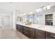 Bathroom featuring dual sinks, wood cabinets, large mirror, and modern fixtures at 1512 Sagefield Way, Logandale, NV 89021