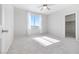 Neutral carpeted bedroom with a ceiling fan and a large window at 1512 Sagefield Way, Logandale, NV 89021