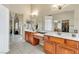 Bright bathroom featuring dual sinks, a makeup vanity, and wooden cabinets at 41 Stablewood Ct, North Las Vegas, NV 89084