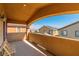 Covered patio featuring two chairs, a stucco railing, and an arch with a view of the neighborhood at 41 Stablewood Ct, North Las Vegas, NV 89084