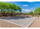 Community sand volleyball court featuring a net, gravel, and a blue sky at 41 Stablewood Ct, North Las Vegas, NV 89084