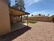 Spacious backyard featuring a covered patio, modern landscaping, and a fenced perimeter at 5653 White Cap St, Las Vegas, NV 89110