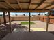 View from the covered backyard patio to a fenced yard with modern landscaping at 5653 White Cap St, Las Vegas, NV 89110