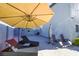 Backyard patio area featuring lounge chairs, an umbrella for shade, and a privacy wall at 7800 Four Seasons Dr, Las Vegas, NV 89129
