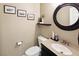 Powder room featuring dark cabinets, stylish mirror, and decorative art at 7800 Four Seasons Dr, Las Vegas, NV 89129