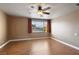 Bright bedroom features hardwood floors, a ceiling fan, and view of the neighborhood at 7800 Four Seasons Dr, Las Vegas, NV 89129
