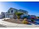 Charming two-story home with a two-car garage and desert landscaping, including a palm tree and colorful flowering shrubs at 7800 Four Seasons Dr, Las Vegas, NV 89129