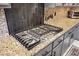 A modern gas cooktop with granite countertops and gray cabinets at 7800 Four Seasons Dr, Las Vegas, NV 89129