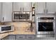 Kitchen with stainless appliances, granite countertops, gray cabinets, and custom cabinet storage at 7800 Four Seasons Dr, Las Vegas, NV 89129