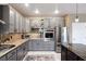 Spacious kitchen with gray cabinets, an island with barstool seating, and stainless steel appliances at 7800 Four Seasons Dr, Las Vegas, NV 89129