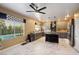 Spacious kitchen with gray cabinets, an island with barstool seating, and a view of the backyard pool at 7800 Four Seasons Dr, Las Vegas, NV 89129