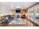 Cozy living room with a fireplace, modern sofa, ceiling fan and natural light at 7800 Four Seasons Dr, Las Vegas, NV 89129