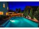 Stunning backyard pool with lush landscaping and outdoor lighting, creating a serene nighttime ambiance at 7800 Four Seasons Dr, Las Vegas, NV 89129