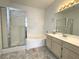 Well-lit bathroom featuring dual sinks, a soaking tub, and a glass-enclosed shower at 855 N Stephanie St # 112, Henderson, NV 89014