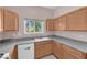 Functional kitchen with wood cabinetry, granite countertops, and stainless steel dishwasher at 2001 Quarry Ridge St # 207, Las Vegas, NV 89117