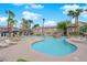 Community pool featuring lounge chairs, tables, umbrellas, and lush palm trees at 2001 Quarry Ridge St # 207, Las Vegas, NV 89117