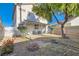 A large backyard featuring a covered patio, rock landscaping, and flowerbeds at 3425 Trilogy Dr, Las Vegas, NV 89108