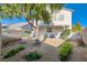 A spacious backyard featuring a covered patio and mature landscaping including a mature shade tree and colorful flowerbeds at 3425 Trilogy Dr, Las Vegas, NV 89108