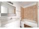 A bathroom with a vanity, toilet, and a shower-tub combo with stylish, neutral tiling at 3508 Rio Robles Dr # A, North Las Vegas, NV 89030