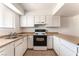 Well-lit kitchen featuring white appliances, bright cabinets, and tile flooring at 3508 Rio Robles Dr # A, North Las Vegas, NV 89030