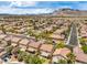 Overhead view of a suburban neighborhood with neat rows of houses, lush trees, and mountain views at 3728 Ashling St, Las Vegas, NV 89129