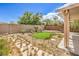 Desert landscaped backyard with rock, small palm trees and synthetic grass at 3728 Ashling St, Las Vegas, NV 89129