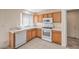Functional kitchen featuring tile floors, wooden cabinets, white appliances, and a white countertop at 3728 Ashling St, Las Vegas, NV 89129