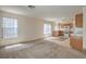 Bright and airy living room featuring carpeted floors, large windows, and access to the kitchen at 3728 Ashling St, Las Vegas, NV 89129