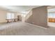 Open-concept living space featuring carpet, a staircase, and access to the kitchen at 3728 Ashling St, Las Vegas, NV 89129