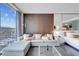 Bright living room showcasing a plush sofa, wood-paneled wall, and expansive windows with city views at 4381 W Flamingo Rd # 1109, Las Vegas, NV 89103